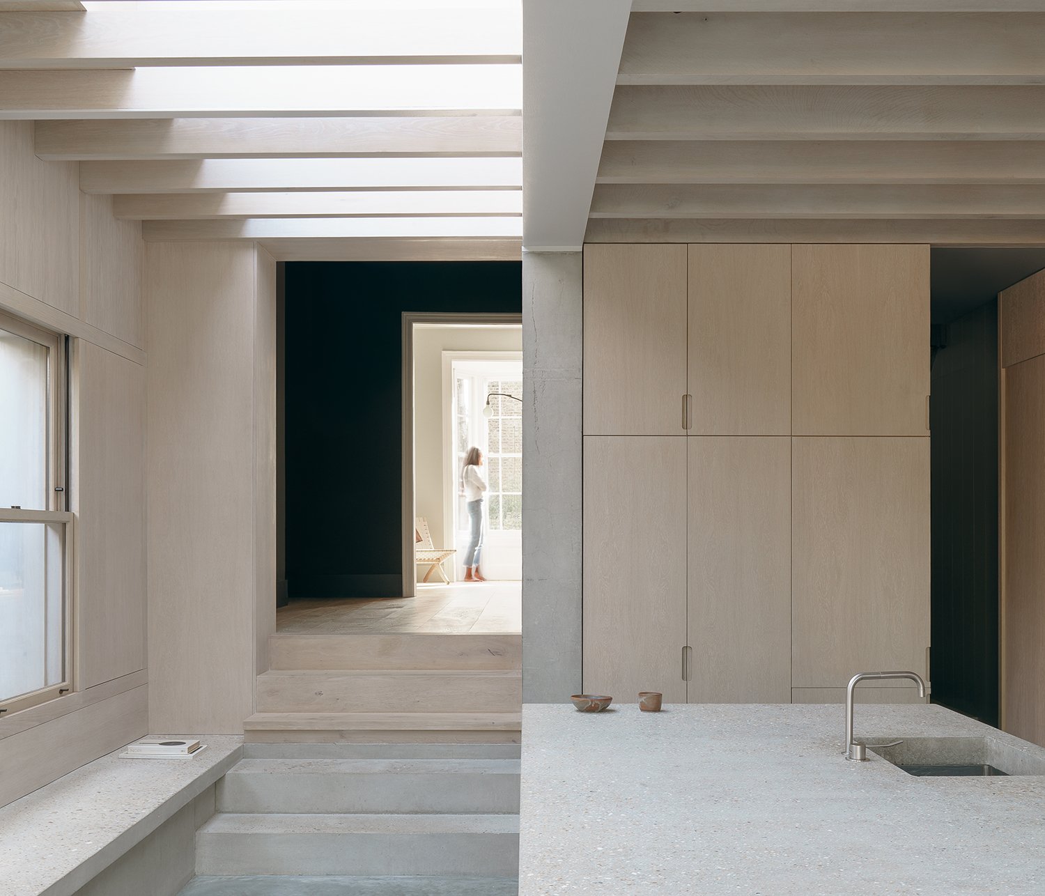 Concrete and light wood kitchen with beamed ceiling and island