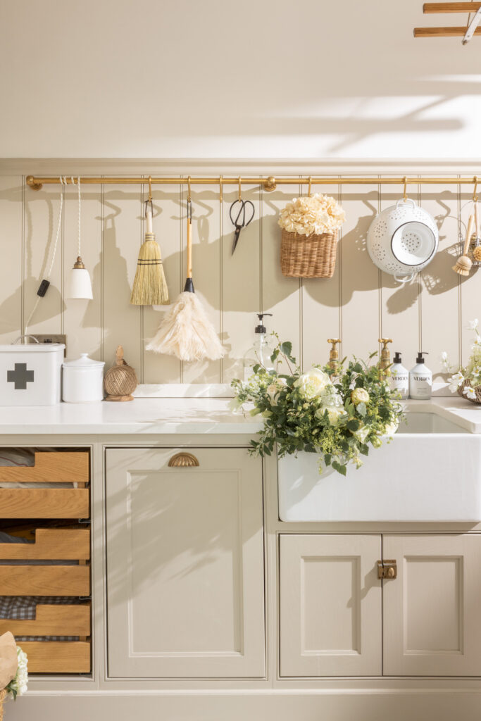 A cream kitchen with a belfast sink and brass taps and hardware