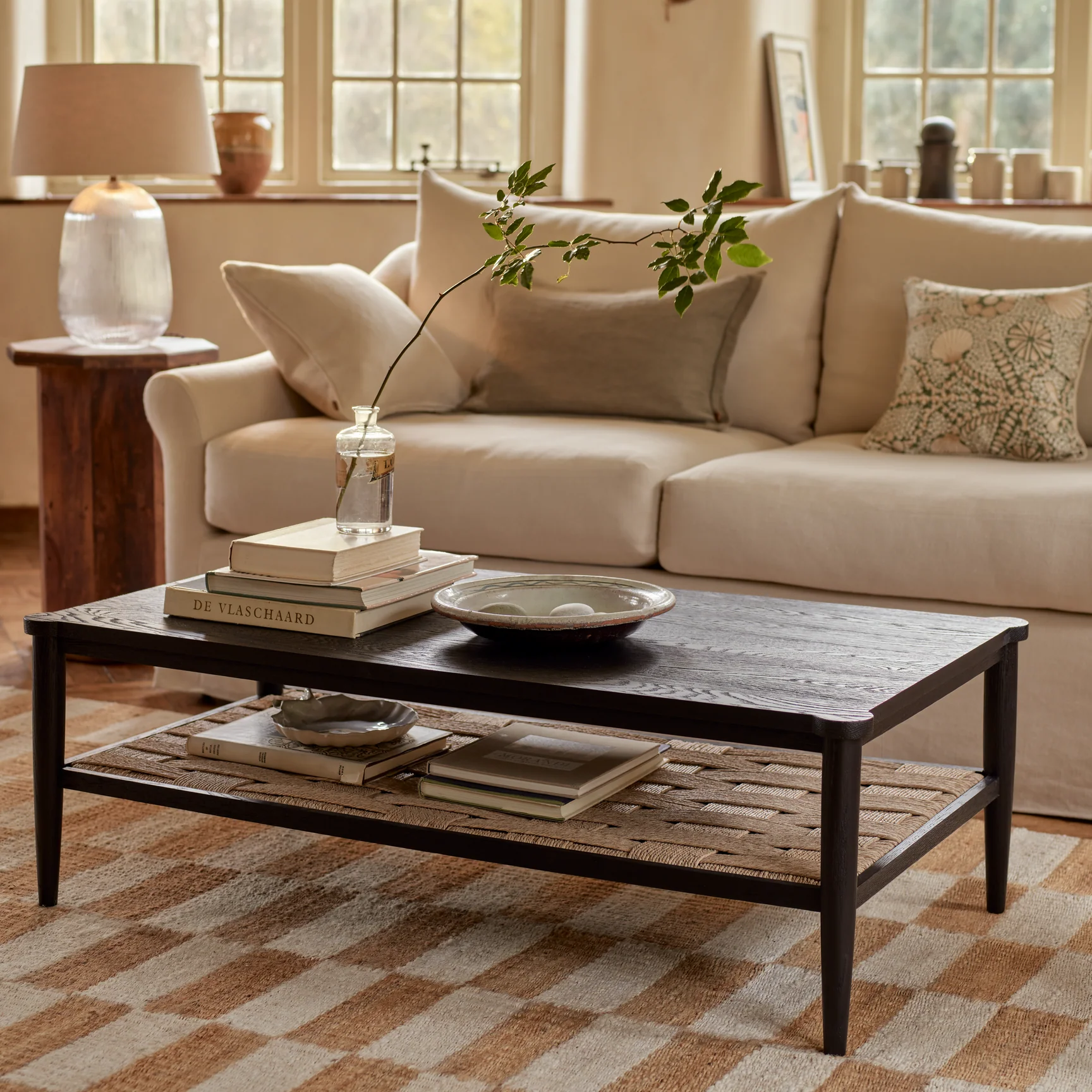 A styled vignette on a black oak coffee table in an elegant living room.